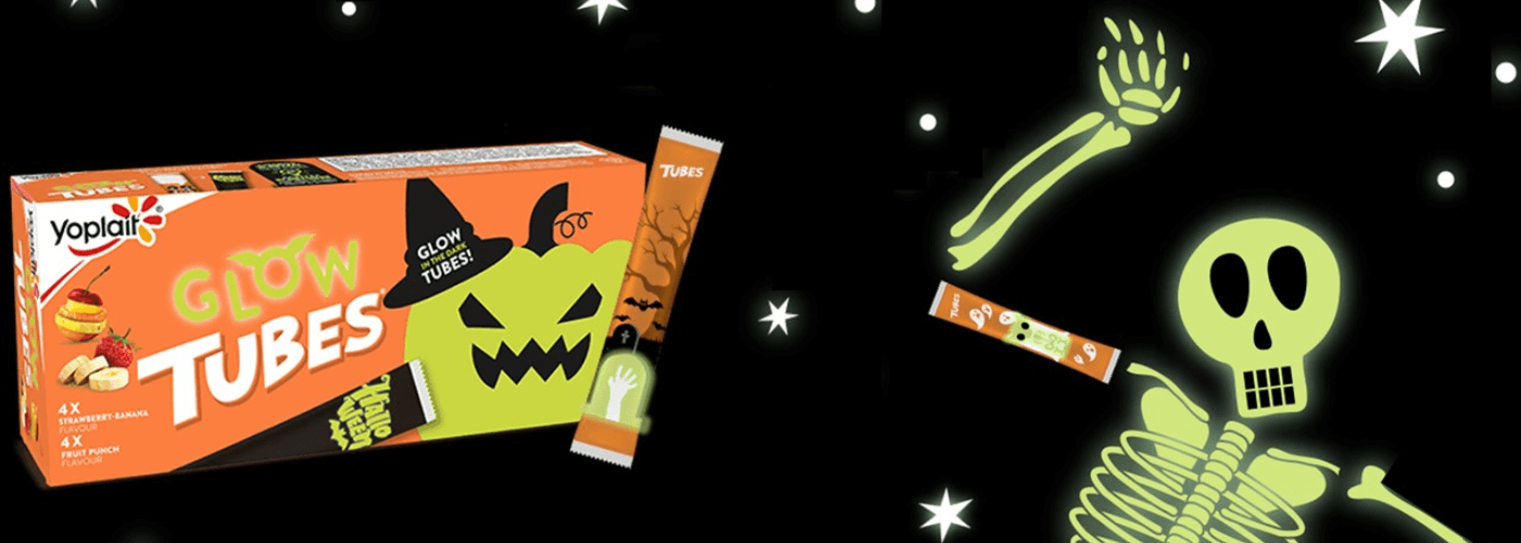 Black background with an orange box packaging shot with "Glow Tubes" Strawberry Banana flavored with a single pack next to it and a glow skeleton on the corner with white stars around it