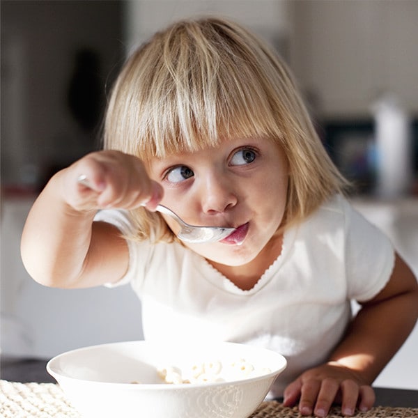 Little girl eating a bowl of cereal